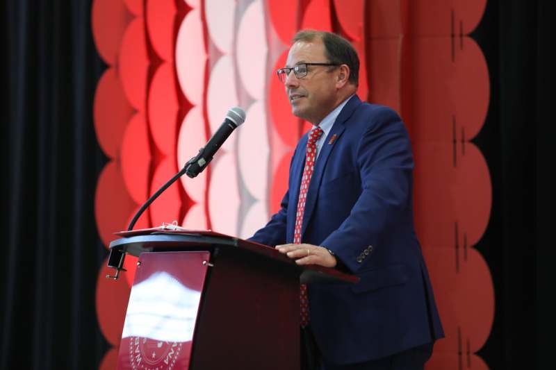 a man standing at a podium with a microphone
