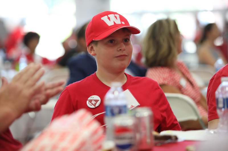 a boy wearing a red hat and a badge