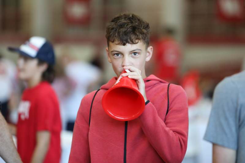 a boy in a red hoodie drinking from a red horn