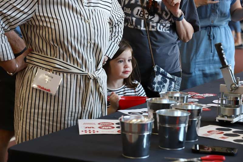 a child sitting at a table with a woman standing behind her