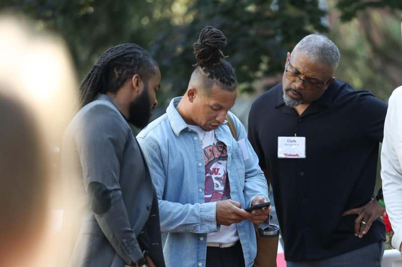 a group of men looking at a phone