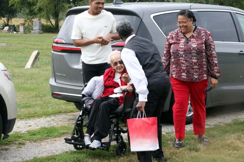 a group of people standing next to a woman in a wheelchair