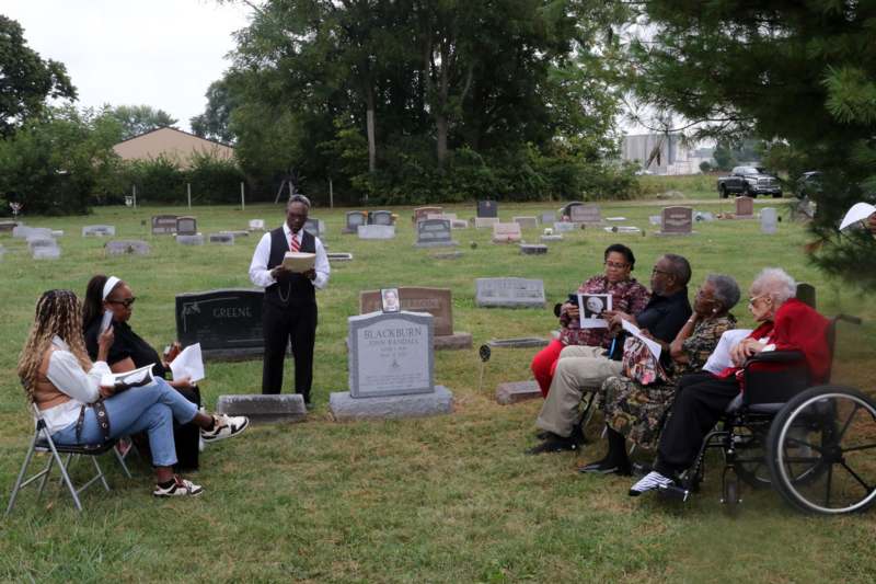 a group of people sitting in a cemetery