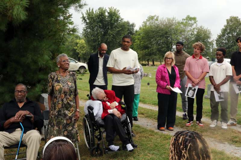 a group of people standing in a grassy area