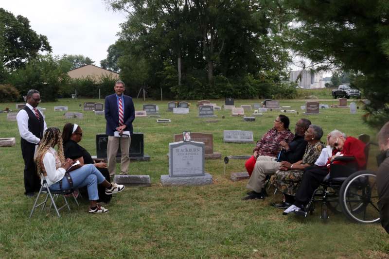 a group of people sitting in a cemetery
