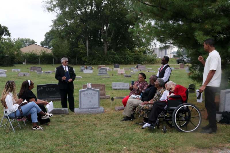 a group of people sitting in a cemetery