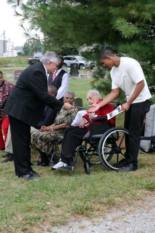 a man in a suit standing next to a woman in a wheelchair