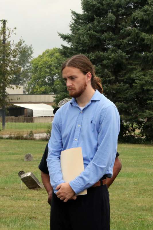 a man in a blue shirt holding a piece of paper