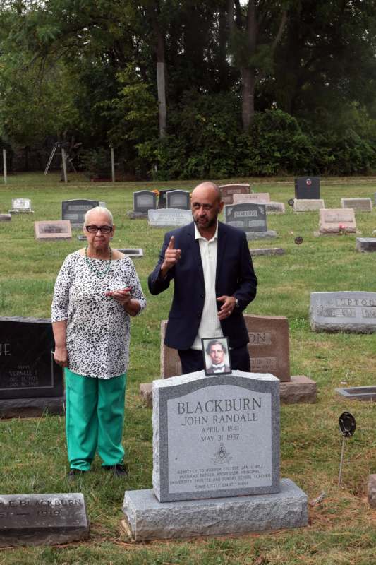 a man and woman standing in a cemetery