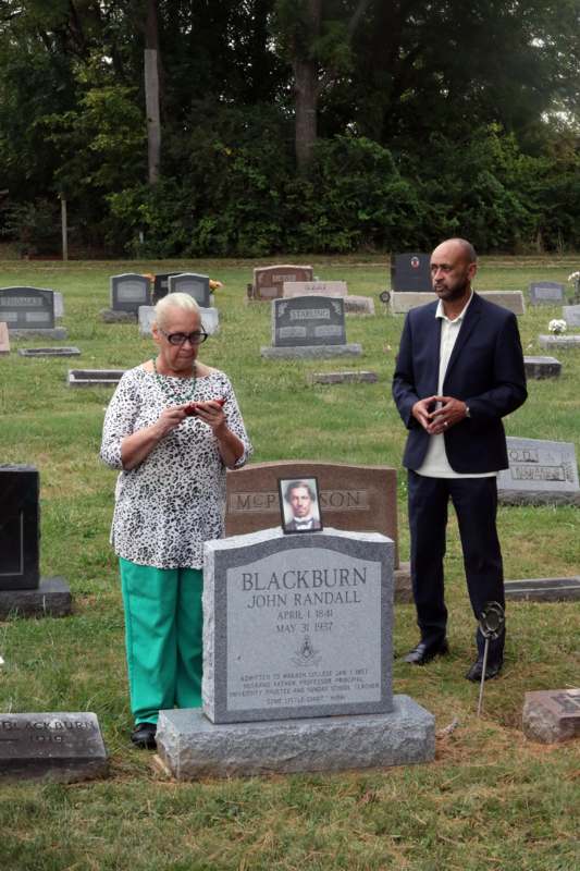 a man and woman standing in a cemetery