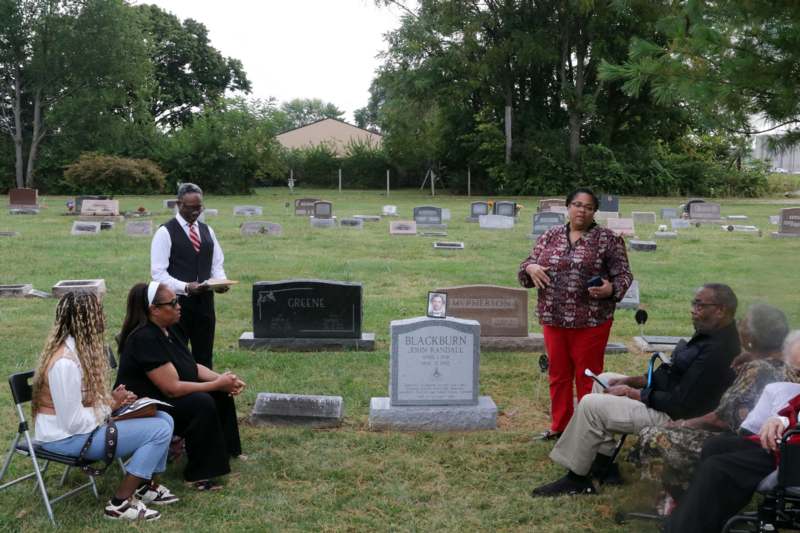 a group of people standing around a cemetery