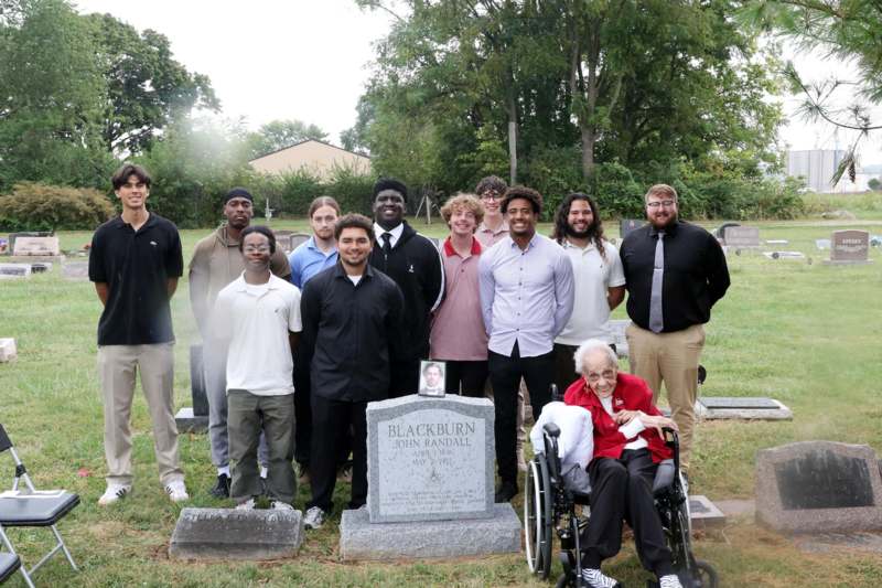 a group of people standing in a cemetery