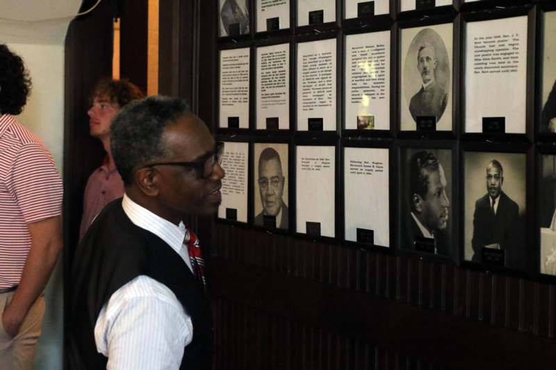 a man looking at a wall of pictures