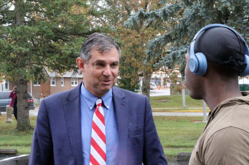 a man in a suit and tie talking to another man