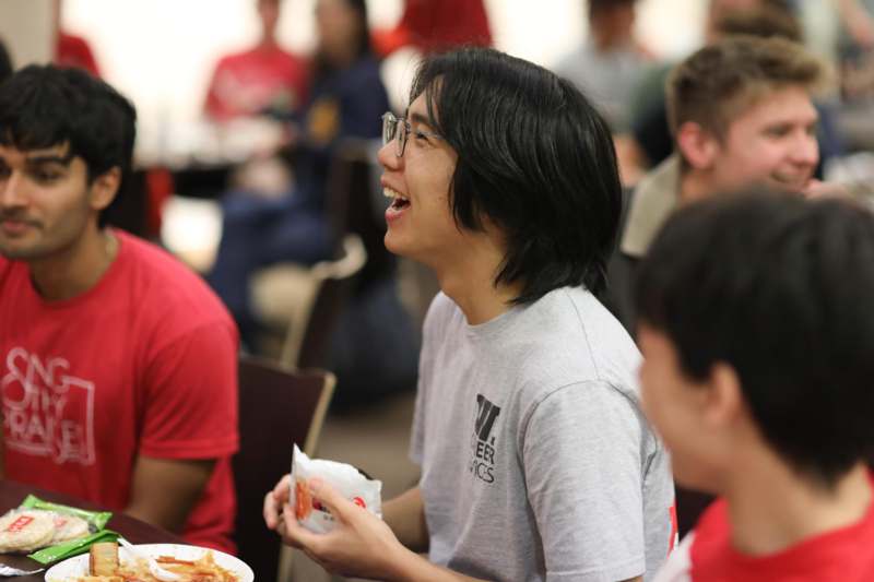a man laughing while holding food