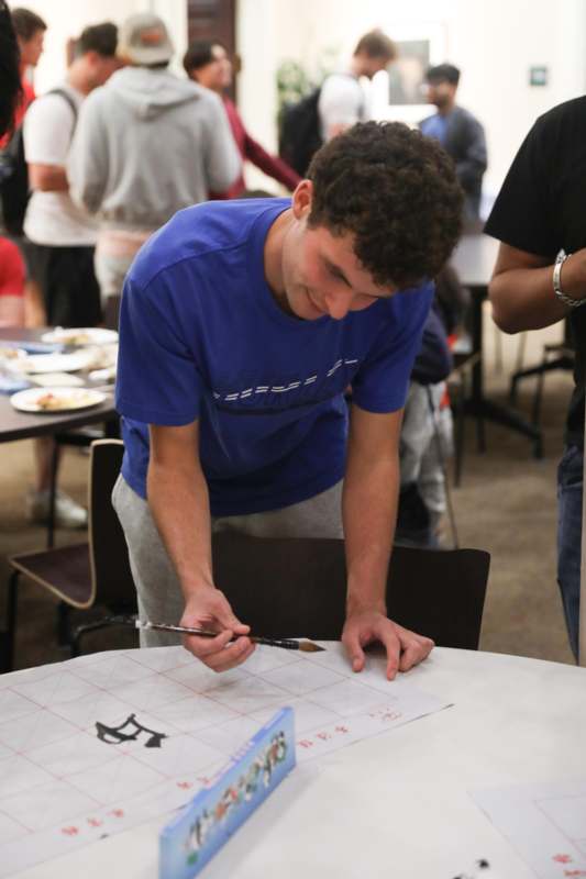 a man painting on a paper