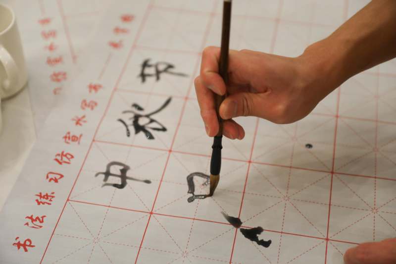 a person painting on a paper