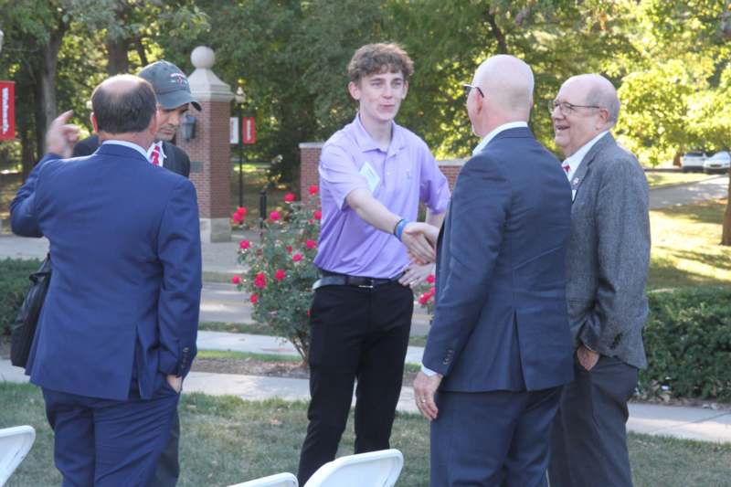 a man shaking hands with other men