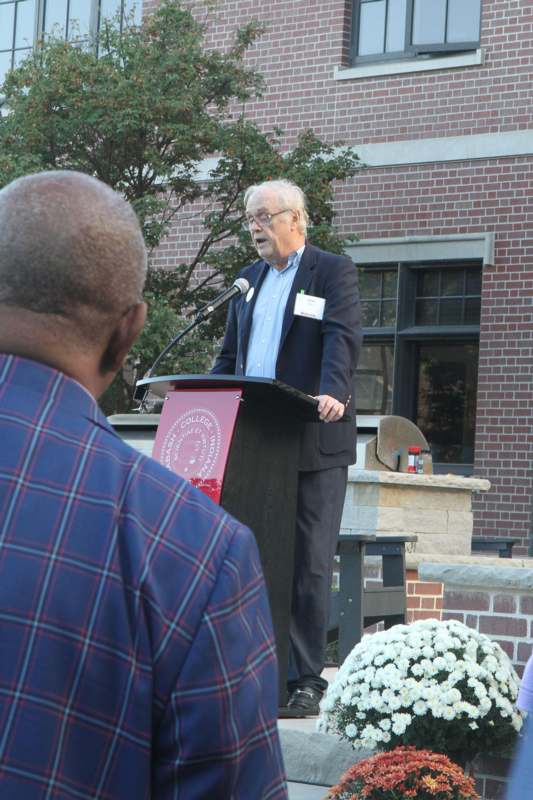 a man standing at a podium with a microphone