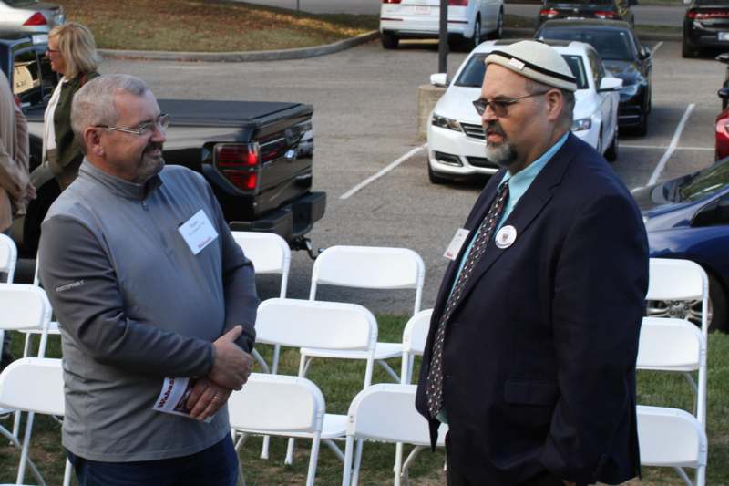 a group of men standing next to white chairs