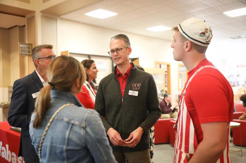 a man standing in a room with people around him