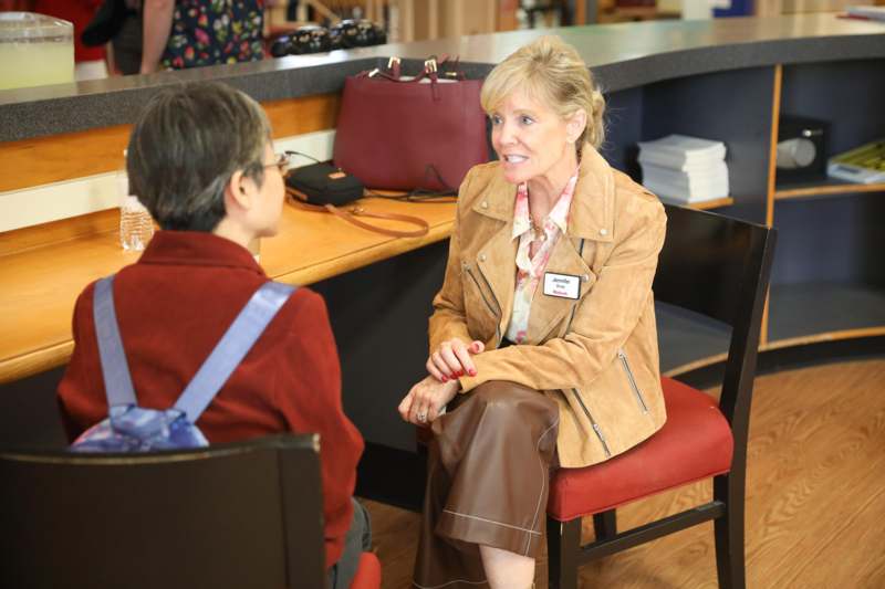 a woman sitting at a table with another woman