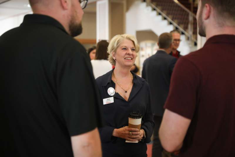 a woman holding a coffee cup and smiling