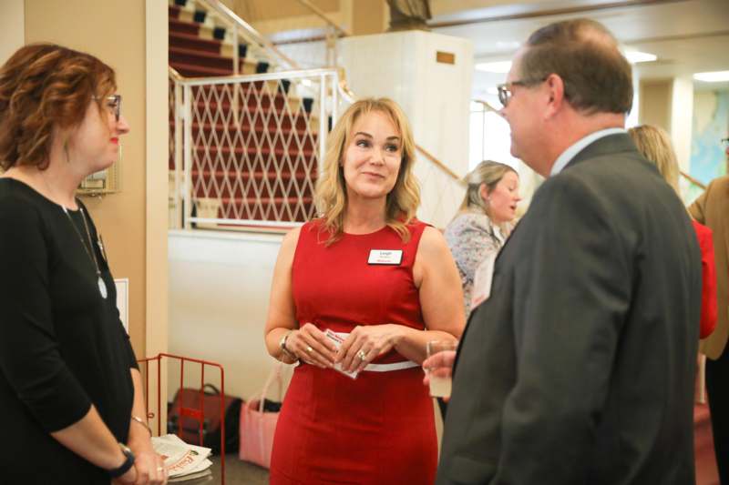 a woman in a red dress talking to a man