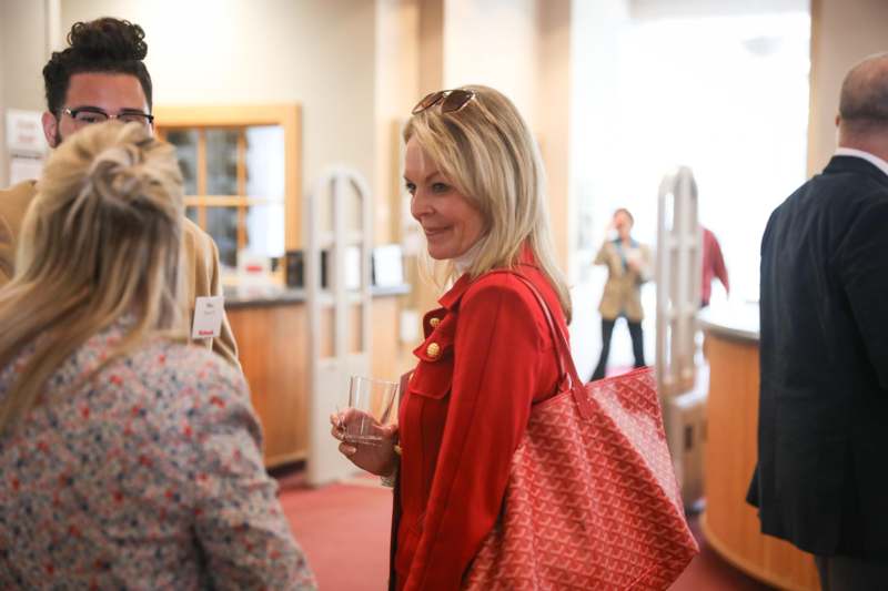 a woman in a red coat holding a red bag