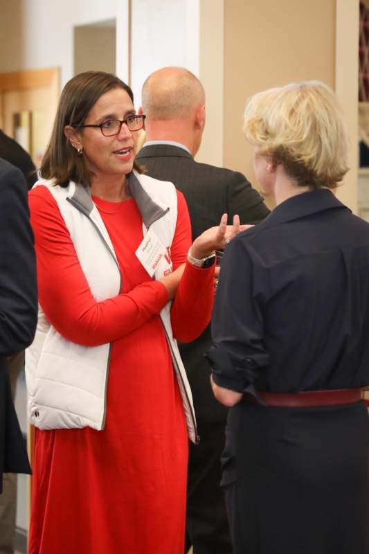 a woman in a red dress talking to a woman in a dark blue dress