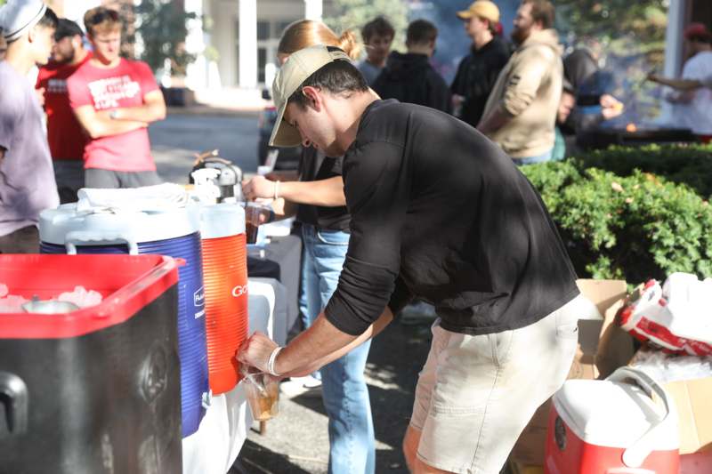 a man pouring a drink into a container