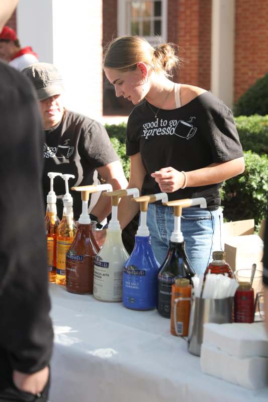 a woman standing next to a table with bottles of liquid