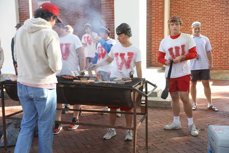 a group of people standing around a grill