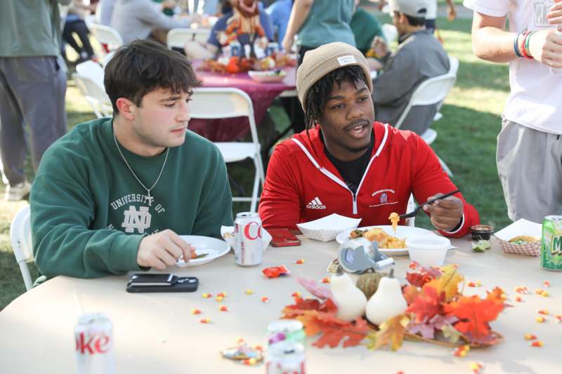 a group of men sitting at a table eating