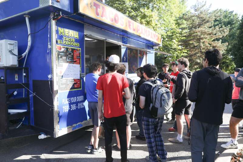 a group of people standing in front of a food truck