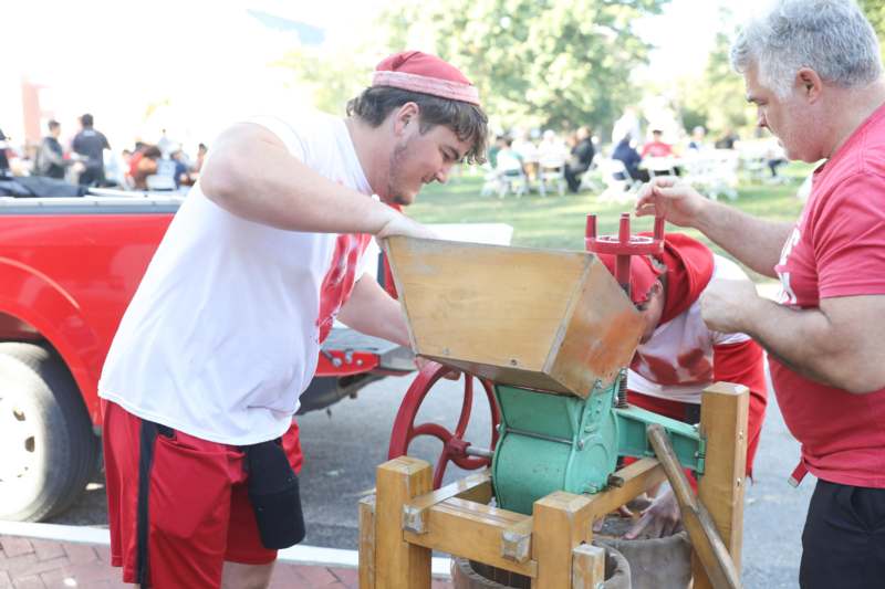 a man in red shorts and a red hat working on a machine
