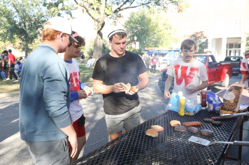 a group of men standing around a table with food on it