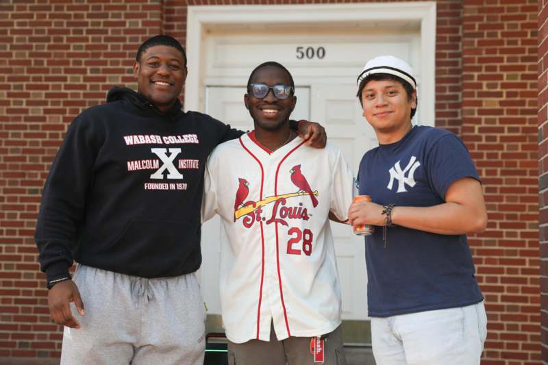 a group of men standing in front of a brick building