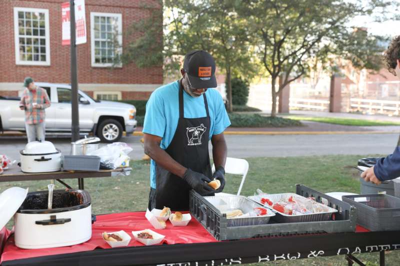 a man wearing an apron and gloves preparing food