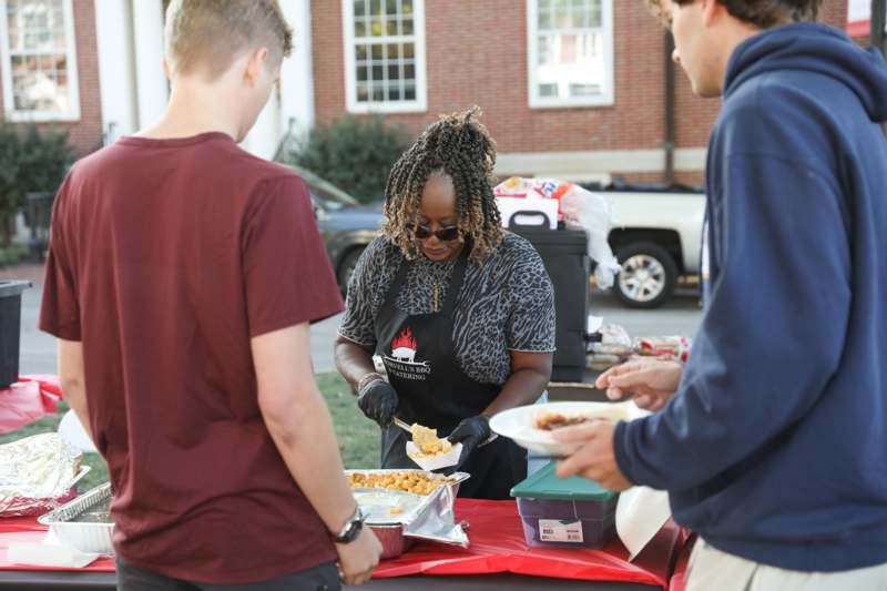 a woman serving food to a group of people