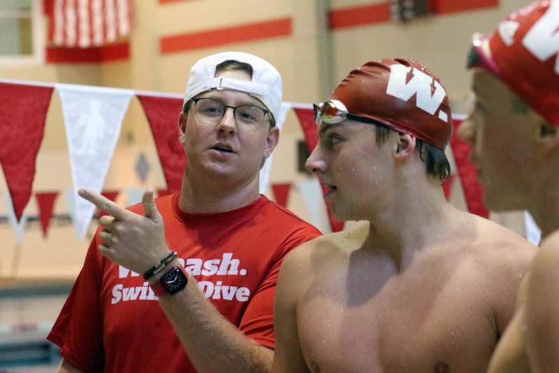 a man pointing to a man in a swim cap