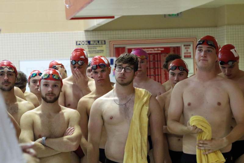 a group of men in swim caps and goggles