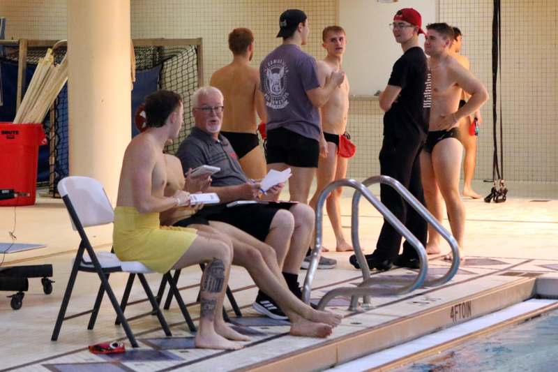 a group of people sitting on chairs by a pool