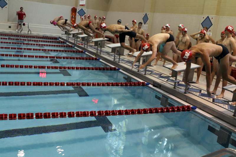 a group of people diving into a pool