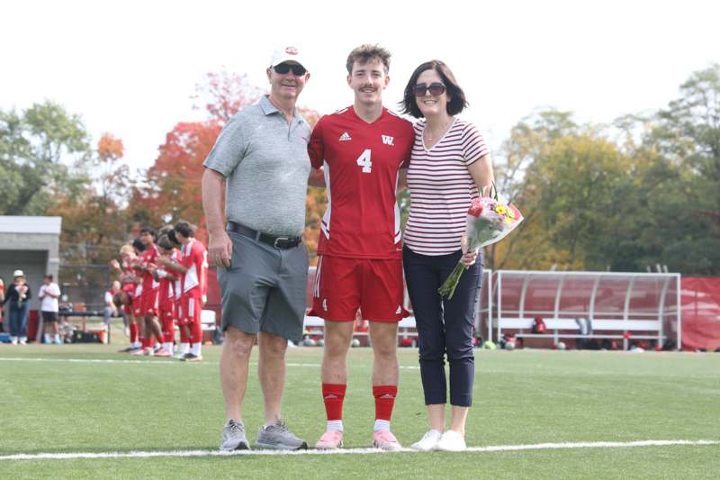 a group of people standing on a field with people in the background