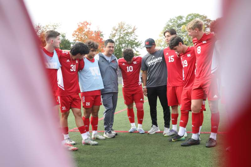 a group of men in red uniforms standing together on a field