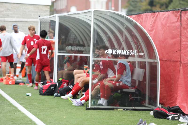 a group of football players sitting in a football dugout
