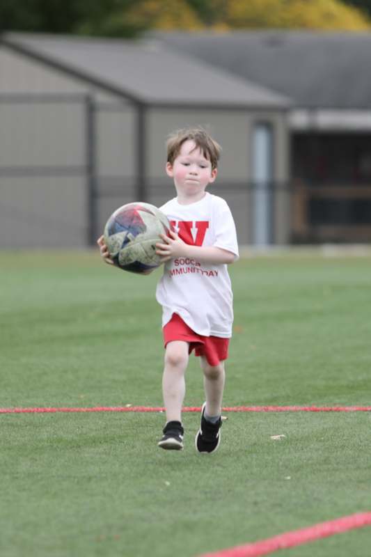 a boy running with a football ball