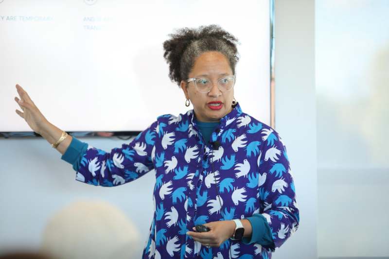 a woman in glasses holding a device