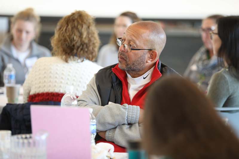 a man sitting at a table with his arms crossed